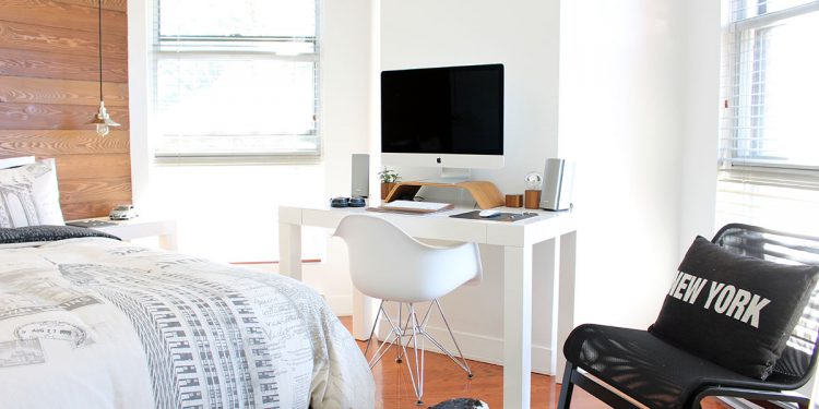 White bedroom or dorm room with desk and computer monitor