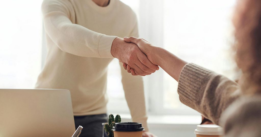 a realtor and a new home buyer shaking hands