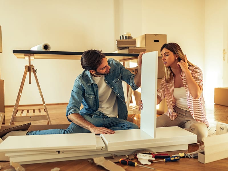 Two people taking apart a table