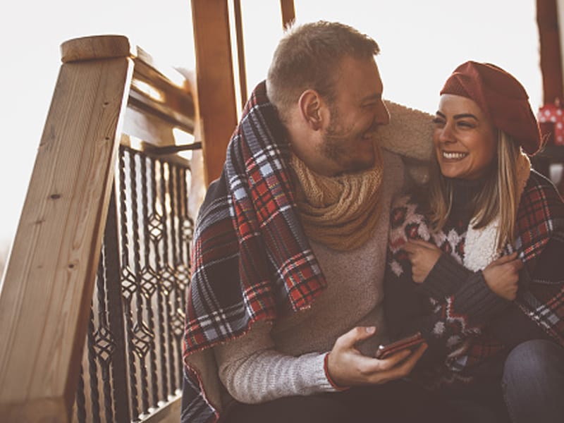couple wrapped in blanket on outdoor steps
