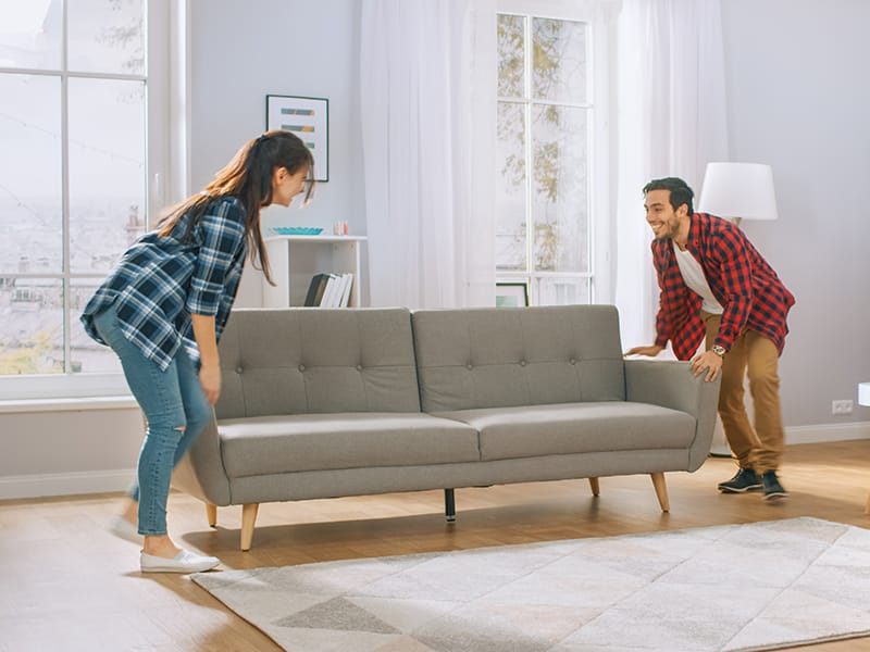Two people moving a couch