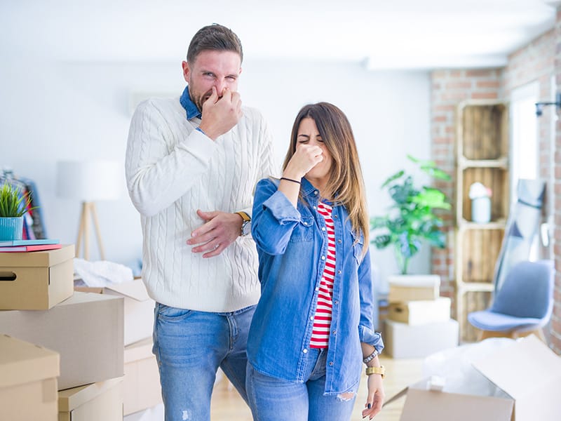 smells in house - couple pinching noses