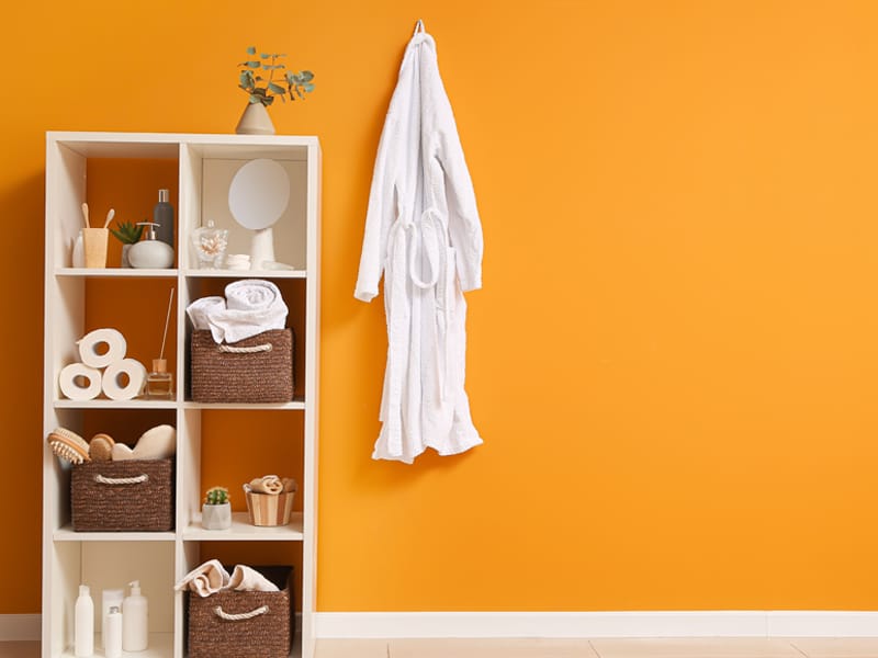 vertical shelving unit and robe hanging on wall hook