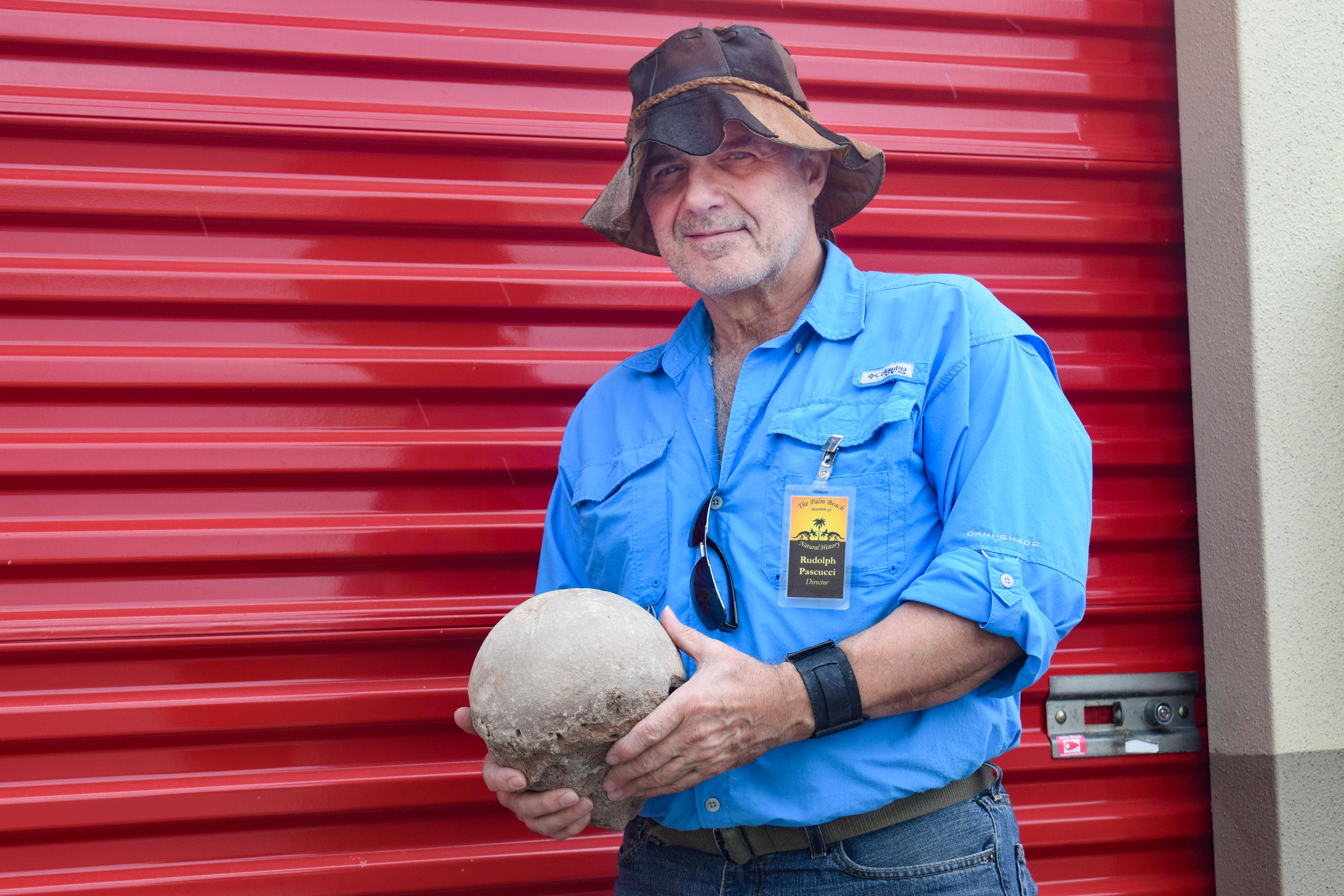 Rudolph Pascucci holding an artifact outside of his storage unit