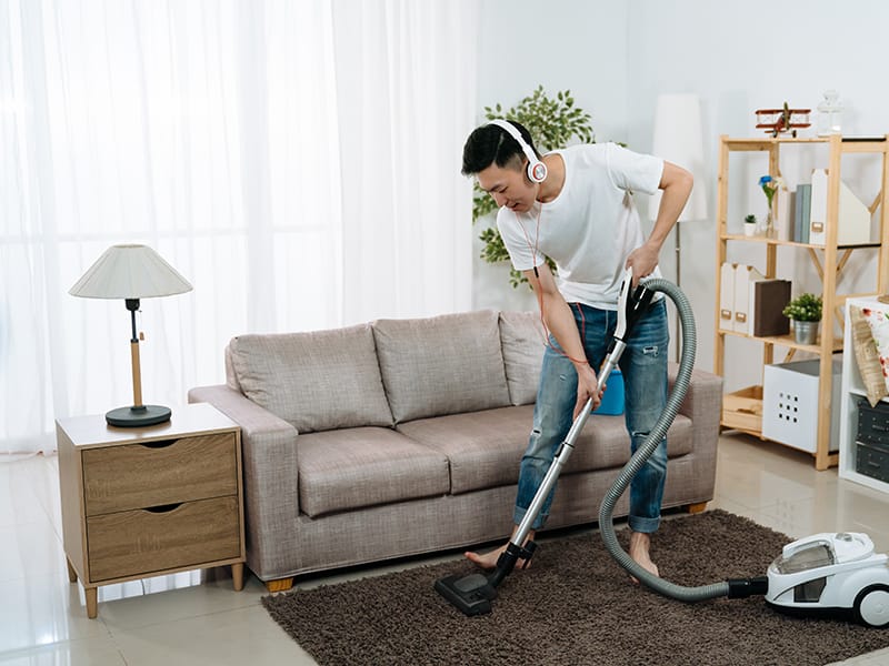 man vacuuming rug