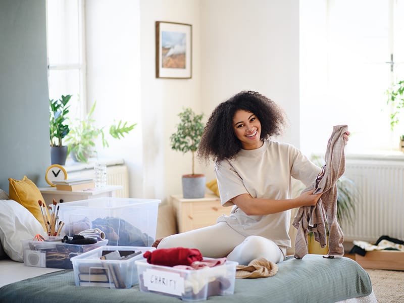 Woman sorting clothing into bins